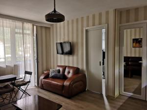 高尼奥Vacation home in Gonio的客厅配有棕色真皮沙发和电视