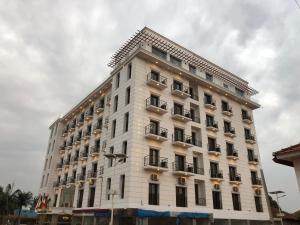 比绍Bissau Royal Hotel的白色的建筑,旁边设有阳台