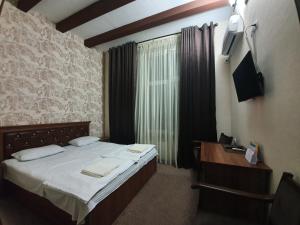 撒马尔罕Hotel Anor的一间小卧室,配有一张床和电视