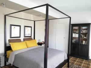 克莱蒙费朗Monts Dôme的一间卧室配有一张带黄色枕头的天蓬床