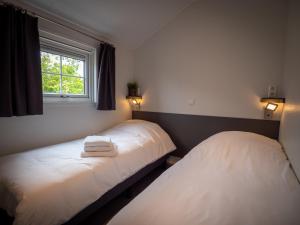 哈林亨Luxe Lodge Zeehoeve的带窗户的客房内的两张床