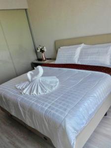 华欣The Pine Hua Hin的白色的床和白色的天鹅