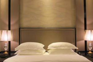 比沙堡Malfa Hotel Apartments的一间卧室配有一张带两张台灯的床铺。