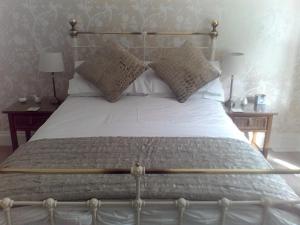 查尔斯敦Baytree B&B的卧室配有一张带白色床单和枕头的大床。