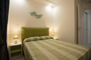 费尔蒂利亚Appartamento Roberto House的一间小卧室,配有一张带两盏灯的绿床