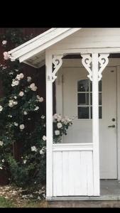 KisaYxefall Norrgården的一座有灌木的房子的白色前门