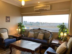 拉比格Dorar Rabigh Complex Residential Units的带沙发、桌子和窗户的客厅