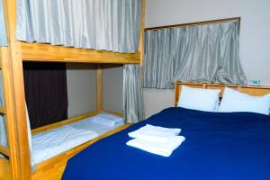 东京花庵旅舍的一间卧室配有两张双层床,铺有蓝色床单。