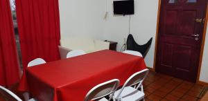 奥拉瓦里亚Casa Quinta Las Pintas的一间设有红色桌子和白色椅子的客房