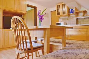 博希尼2 studio & apartment Cvetek Bohinj的厨房配有木桌和两把椅子