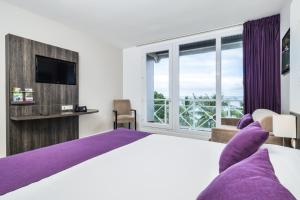 努美阿博里瓦奇酒店的一间卧室设有一张大床和一个大窗户