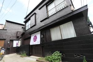 东京Villa Ikebukuro的一间黑色房子,旁边有一个标志
