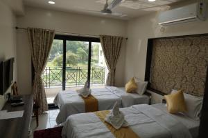 加尔各答Rama Golden Root New town的酒店客房设有两张床和窗户。