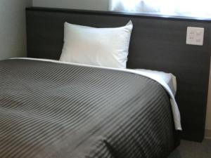 仙台仙台东橘子酒店的靠窗的带白色枕头的床