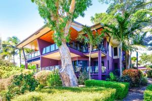 汉密尔顿岛昂克拉吉尔酒店的一座紫色房子前面有棕榈树
