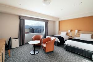 札幌东急札幌卓越大酒店的酒店客房设有两张床和窗户。