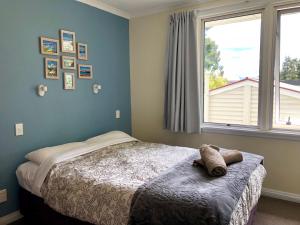 特卡波湖Tailor Made Tekapo Accommodation - Guesthouse & Hostel的一间卧室设有一张床和一个大窗户