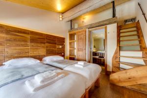 瓦勒迪泽尔Chalet Hotel Du Fornet的一间卧室设有一张带木墙的大床