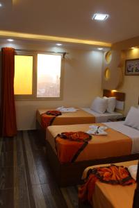 开罗开罗奥西里斯酒店的酒店客房设有三张床和窗户。