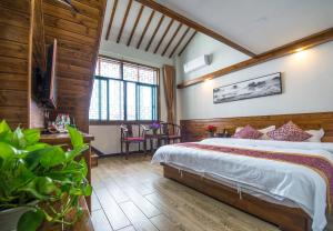 黟县宏村瑞云精品酒店的一间带一张大床的卧室,位于带木墙的房间