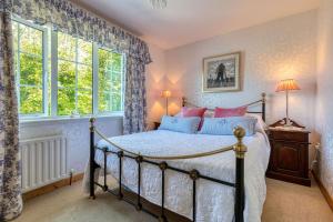 Union HallShearwater Country House Accommodation的一间卧室设有一张床和两个窗户。