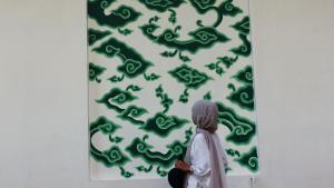 井里汶井里汶由地平线没特兰酒店的一位女人看着墙上的绿色画