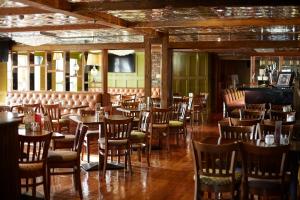 卡洛丁恩瑞酒店的用餐室配有木桌和椅子
