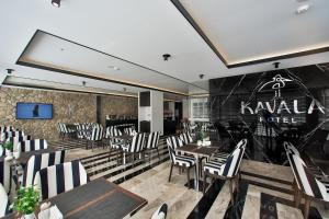 伯萨Kavala Hotel的一间带桌椅的餐厅以及一面墙