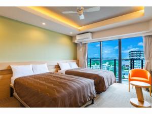 宜野湾市Yenns Marina Inn Mercy的酒店客房设有两张床和大窗户。