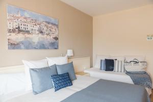 雅弗郎其特拉玛尔酒店的一间卧室配有一张带蓝色和白色枕头的床