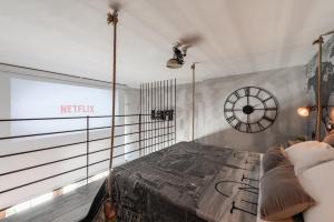 滨海波利尼亚诺The Loft Polignano的一间设有一张床和墙上一个时钟的房间