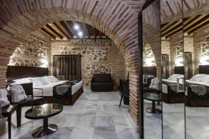 托莱多Hotel Pintor El Greco的酒店客房的砖墙内设有两张床