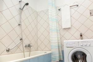 维也纳Pension Sacher - Apartments am Stephansplatz的浴室配有洗衣机和浴缸。