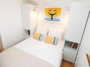 塞特港Le Pouffre, maison de pêcheur au quartier des artistes, clim, WiFi的一间小卧室,配有白色的床和两个枕头