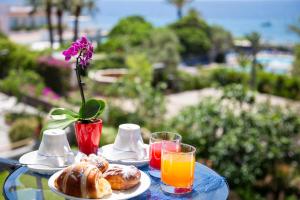 伊斯基亚拉曼多拉酒店的一张桌子,上面放着一盘食物和两杯橙汁
