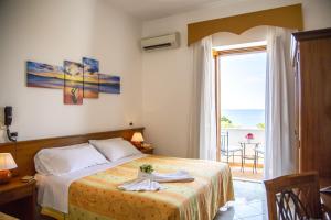 伊斯基亚拉曼多拉酒店的一间卧室设有一张床,享有海景