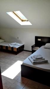 卡巴丁卡Hotel Acropolis Palace的一间卧室设有两张床和天窗