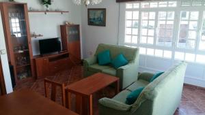 拉赫Insua的客厅配有两把椅子、一张桌子和电视
