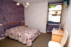 蒙梅利扬乔治酒店的一间卧室配有一张床、一个窗口和一张书桌