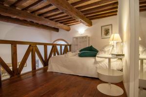 佩鲁贾Umbrian Concierge - Cozy Loft Vannucci的一间卧室配有一张带绿色枕头的床和一张桌子