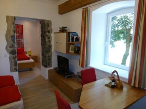 利恩茨利恩茨埃格度假公寓的客厅设有餐桌和窗户
