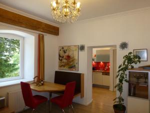 利恩茨利恩茨埃格度假公寓的一间带桌子和红色椅子的用餐室
