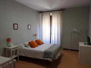 莱昂圣马丁旅馆的一间卧室配有带橙色枕头的床和窗户。