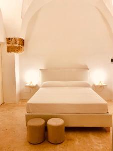 马蒂诺Palazzo Boccaccio的一间卧室配有一张带两张凳子和两盏灯的床。