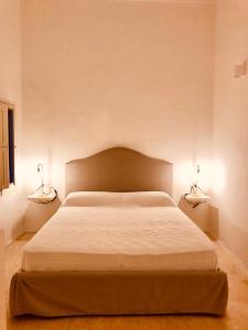 马蒂诺Palazzo Boccaccio的卧室配有一张带两盏灯的墙壁床。