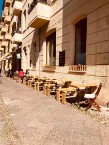 柏林Pension Kaffeefreunde的建筑物前的一排木桌