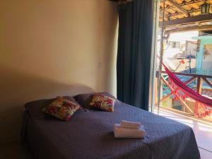 阿布拉奥Pousada Porto do Sol的一张带两个枕头的床和窗户