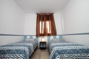 罗萨里奥港Atlantic Loft的两张睡床彼此相邻,位于一个房间里