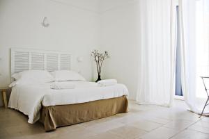特拉尼La Mitria的白色卧室设有一张白色墙壁的大床