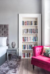 爱丁堡Spacious newly refurbished central apt的一间带沙发和书架的卧室